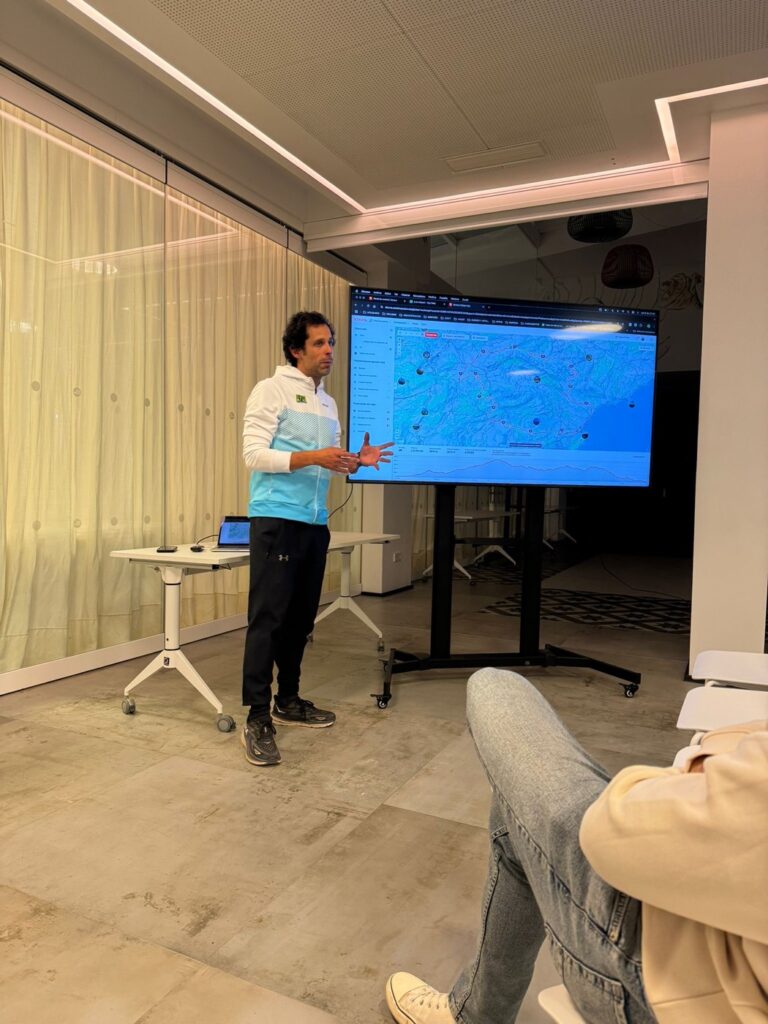 Entrenador de Ezz Baily explicando datos de entrenamiento en una charla con deportistas