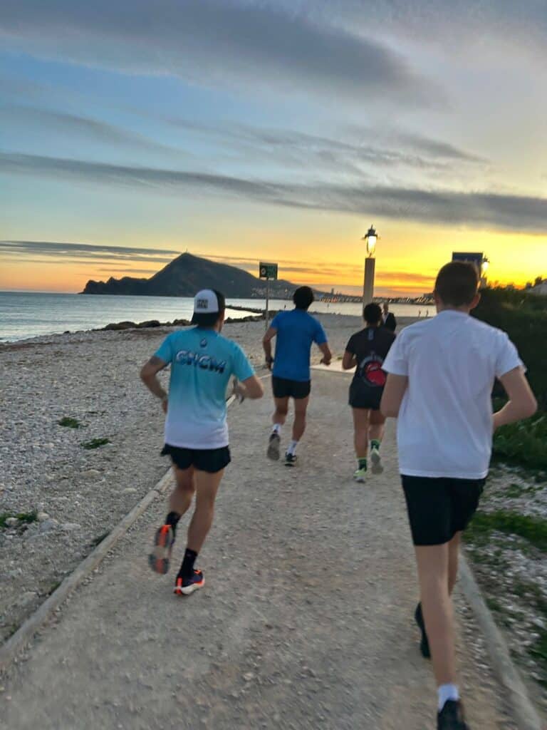 Deportistas de Ezz Baily corriendo junto al mar al amanecer